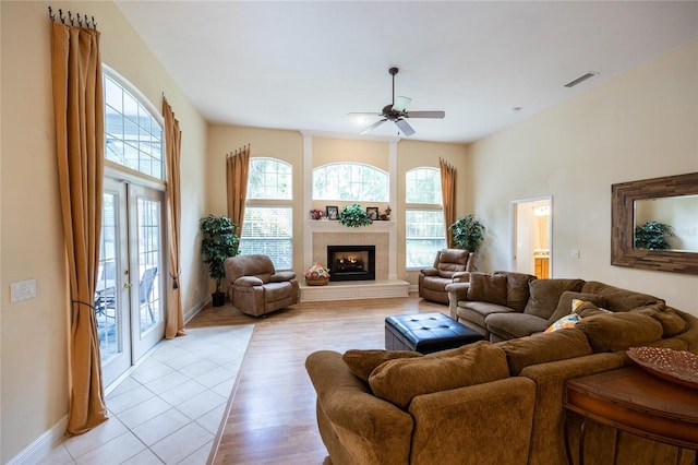 10312 SW 23rd Ave, Gainesville, FL 32607 - living room with ceiling fan, baseboards, a tile fireplace, and light wood finished floors
