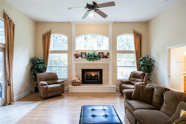 10312 SW 23rd Ave, Gainesville, FL 32607 - living area featuring plenty of natural light, a ceiling fan, a warm lit fireplace, and wood finished floors