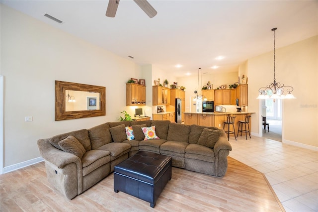 10312 SW 23rd Ave, Gainesville, FL 32607 - living room featuring a chandelier, a ceiling fan, baseboards, and light tile patterned floors