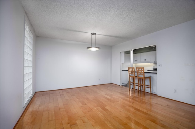 dining room featuring a textured ceiling and light wood-style floors
