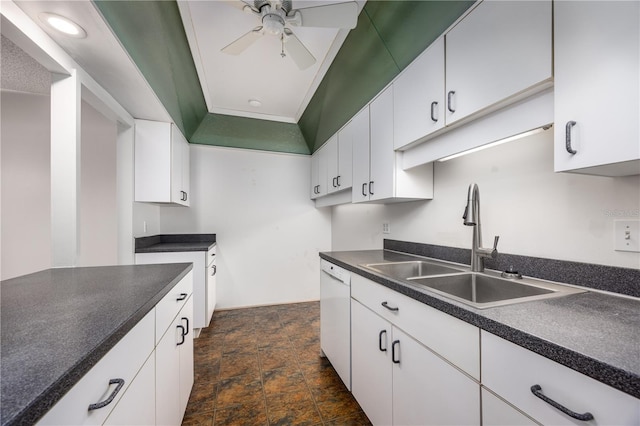 kitchen featuring stone finish floor, white dishwasher, dark countertops, a sink, and a ceiling fan