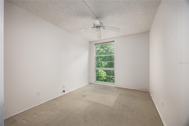 unfurnished room with a textured ceiling, a ceiling fan, and carpet
