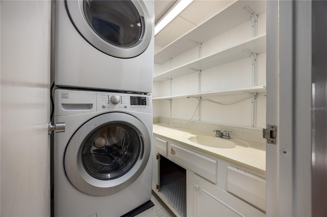 washroom featuring stacked washer and dryer, a sink, light tile patterned floors, and laundry area
