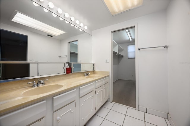bathroom featuring tile patterned floors, double vanity, and a sink