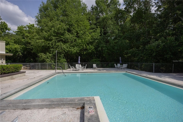 community pool featuring a patio and fence