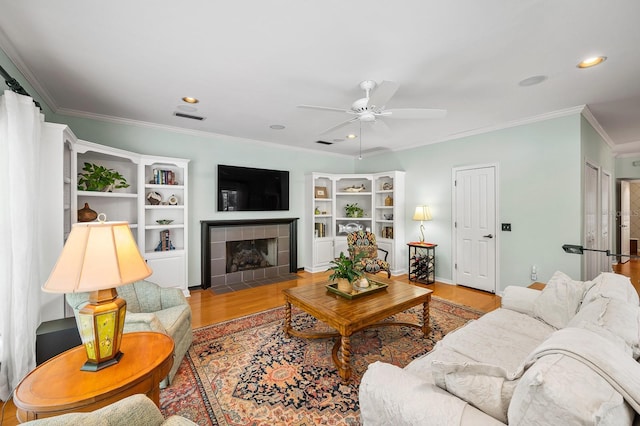 4319 SW 86th Way, Gainesville, FL 32608 - living room with a ceiling fan, wood finished floors, ornamental molding, a tile fireplace, and recessed lighting