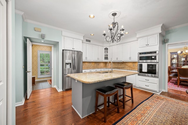 4319 SW 86th Way, Gainesville, FL 32608 - kitchen with a chandelier, appliances with stainless steel finishes, ornamental molding, white cabinetry, and a center island with sink