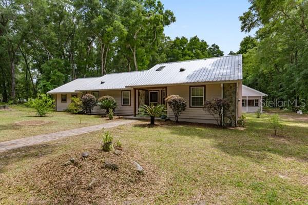 23225 NW County Rd 236, High Springs, FL 32643 - ranch-style home with a front yard and metal roof