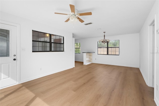 529 NE 12th Ct, Gainesville, FL 32601 - unfurnished living room with a chandelier, light wood-style flooring, a ceiling fan, and baseboards