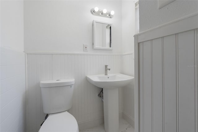 529 NE 12th Ct, Gainesville, FL 32601 - half bath featuring marble finish floors, toilet, and wainscoting