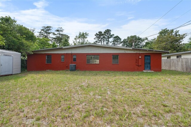 529 NE 12th Ct, Gainesville, FL 32601 - back of house with central AC, a shed, and an outbuilding