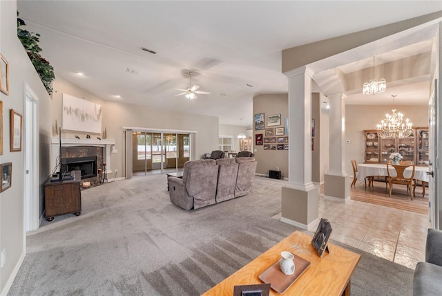 tiled living area featuring carpet floors, a premium fireplace, ceiling fan with notable chandelier, decorative columns, and visible vents