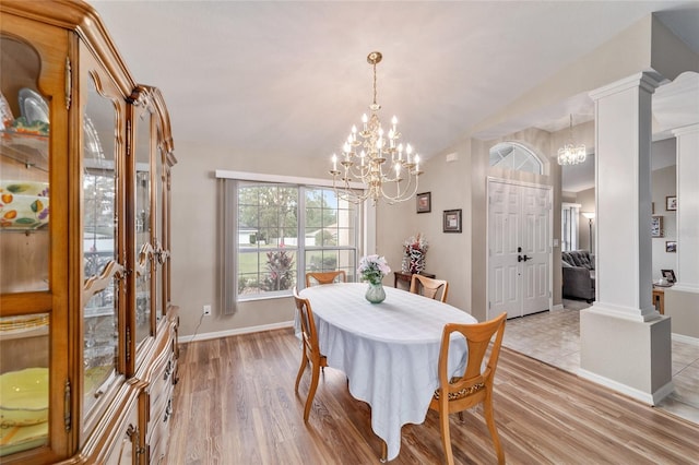 dining space with an inviting chandelier, baseboards, vaulted ceiling, and light wood-style floors