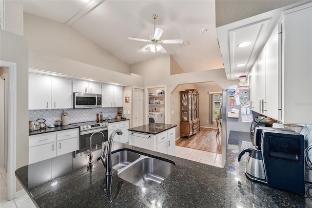kitchen featuring a kitchen island, ceiling fan, white cabinets, a sink, and stainless steel appliances