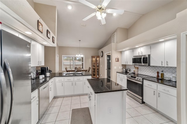 kitchen with vaulted ceiling, decorative backsplash, stainless steel appliances, and light tile patterned flooring