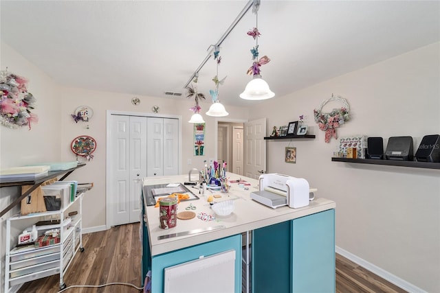 kitchen featuring baseboards, light countertops, dark wood-type flooring, and blue cabinetry