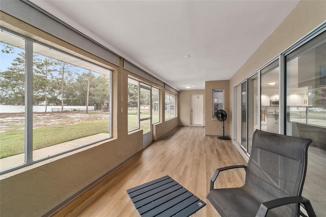 sunroom / solarium featuring a textured wall and wood finished floors