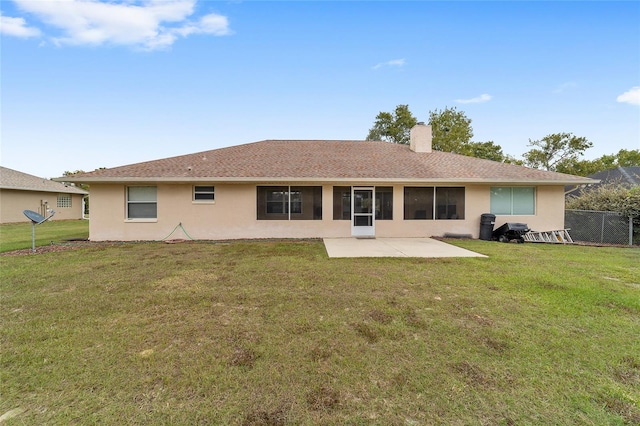 back of property with a lawn, stucco siding, a chimney, and a patio