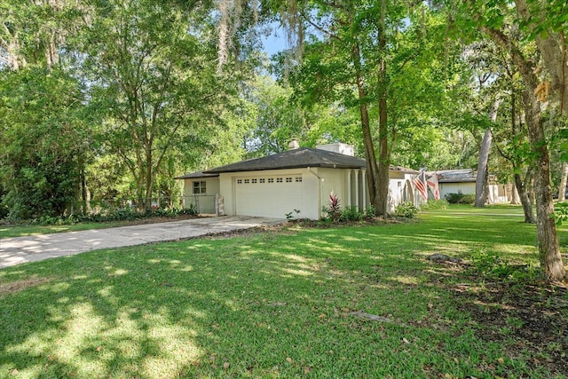 view of front of property with fence, an attached garage, a front lawn, stucco siding, and concrete driveway