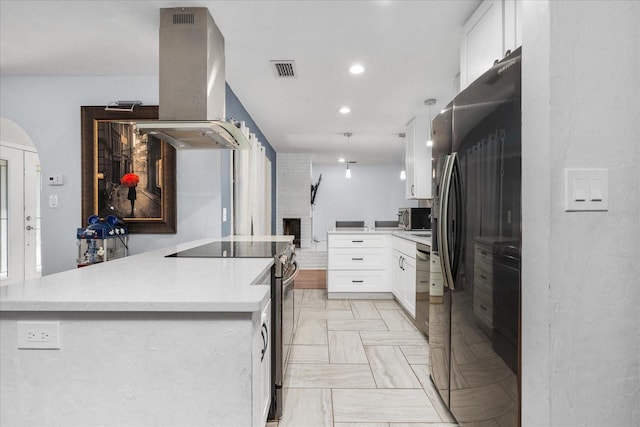 kitchen with visible vents, light countertops, white cabinets, island exhaust hood, and appliances with stainless steel finishes