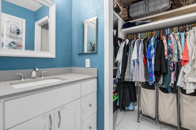 bathroom featuring a spacious closet, tile patterned flooring, and vanity