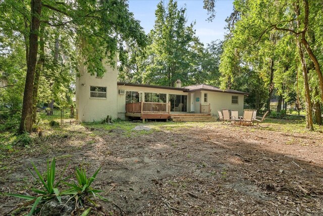 rear view of property with fence and a deck
