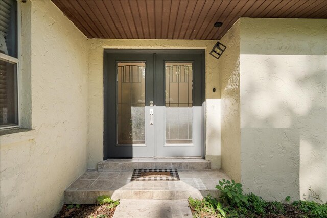 entrance to property with stucco siding and french doors