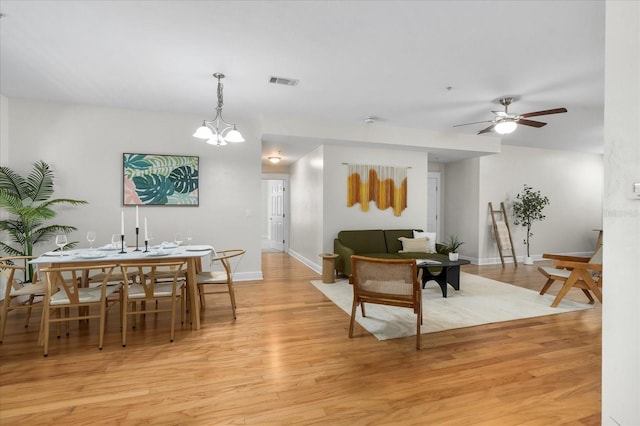 339 NE 2nd Ave, Gainesville, FL 32601 - living room featuring visible vents, baseboards, ceiling fan with notable chandelier, and light wood-type flooring