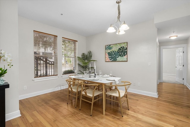 339 NE 2nd Ave, Gainesville, FL 32601 - dining area with baseboards, light wood-type flooring, and a notable chandelier