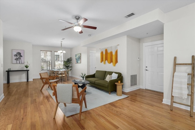339 NE 2nd Ave, Gainesville, FL 32601 - living room featuring baseboards, visible vents, ceiling fan with notable chandelier, and light wood-type flooring