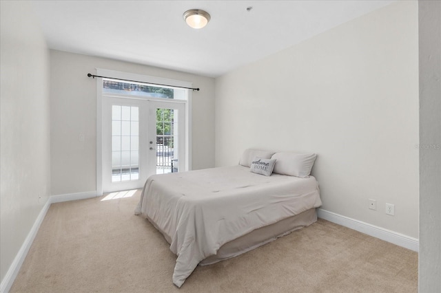 339 NE 2nd Ave, Gainesville, FL 32601 - bedroom featuring baseboards, access to outside, and light colored carpet