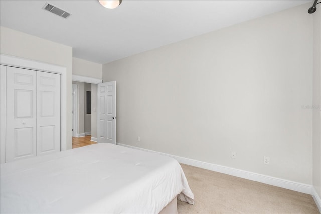 339 NE 2nd Ave, Gainesville, FL 32601 - bedroom with visible vents, baseboards, a closet, and light colored carpet