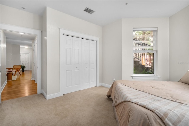 339 NE 2nd Ave, Gainesville, FL 32601 - bedroom with baseboards, visible vents, a closet, and light colored carpet