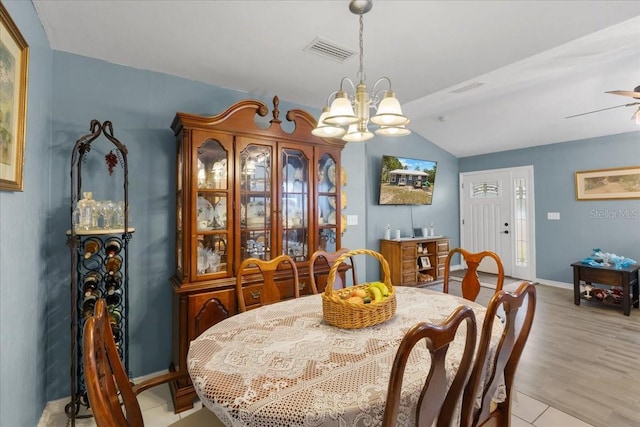 dining room featuring visible vents, a chandelier, lofted ceiling, and baseboards