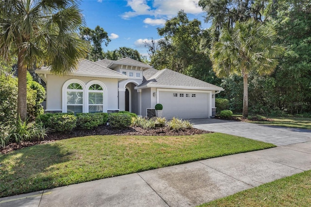 555 NW 134th Way, Newberry, FL 32669 - mediterranean / spanish house featuring concrete driveway, an attached garage, a front lawn, and stucco siding