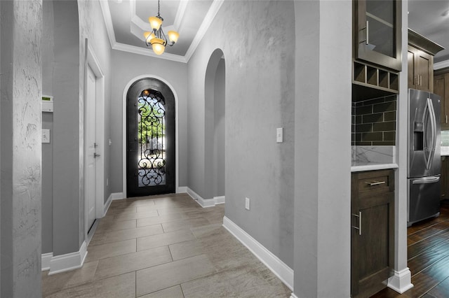 555 NW 134th Way, Newberry, FL 32669 - foyer featuring arched walkways, baseboards, an inviting chandelier, ornamental molding, and a textured wall