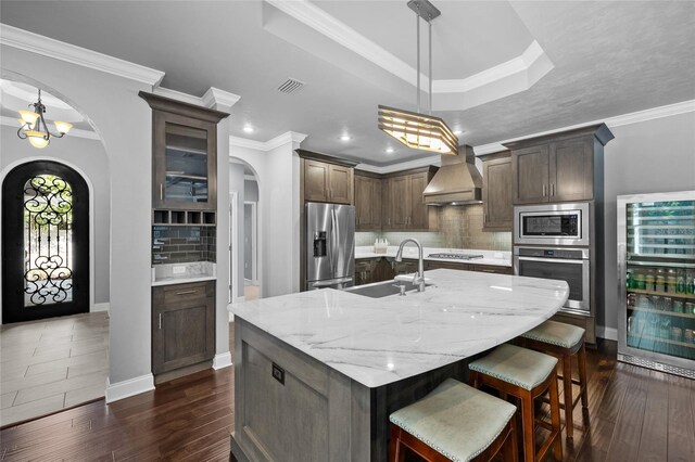 555 NW 134th Way, Newberry, FL 32669 - kitchen with appliances with stainless steel finishes, a sink, arched walkways, premium range hood, and wine cooler