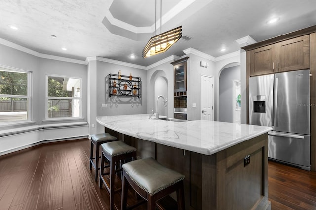 555 NW 134th Way, Newberry, FL 32669 - kitchen featuring light stone countertops, a center island with sink, dark wood-type flooring, stainless steel fridge with ice dispenser, and arched walkways