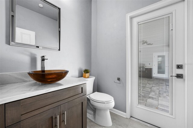 555 NW 134th Way, Newberry, FL 32669 - bathroom with vanity, baseboards, tile patterned floors, and toilet
