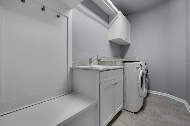 555 NW 134th Way, Newberry, FL 32669 - washroom featuring a sink, washer and clothes dryer, cabinet space, and baseboards