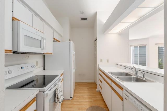 1020 NW 124th Dr, Newberry, FL 32669 - kitchen featuring white appliances, a sink, light wood finished floors, light countertops, and white cabinetry