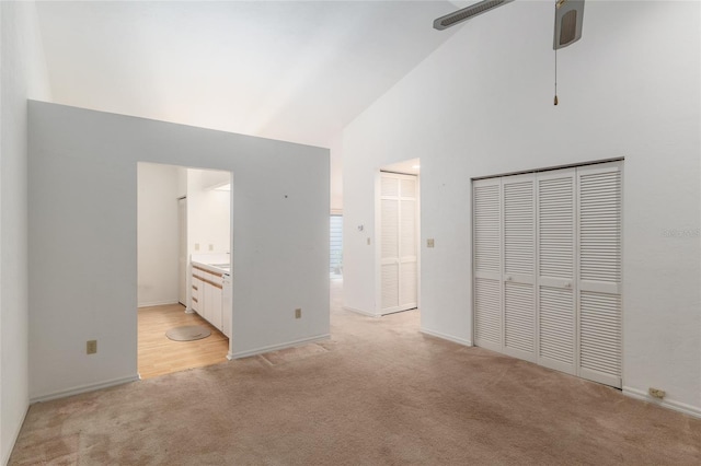 1020 NW 124th Dr, Newberry, FL 32669 - unfurnished bedroom featuring light colored carpet, high vaulted ceiling, ensuite bathroom, and baseboards