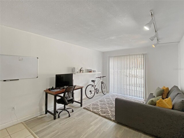 office area featuring a textured ceiling, rail lighting, and wood finished floors