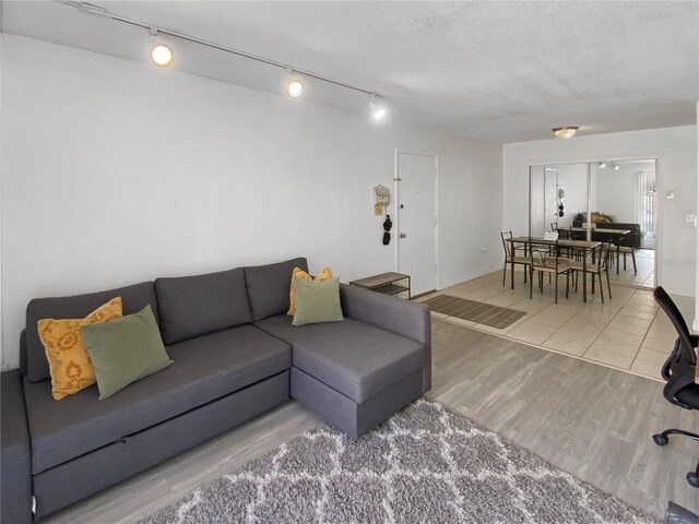 living room with track lighting and wood finished floors
