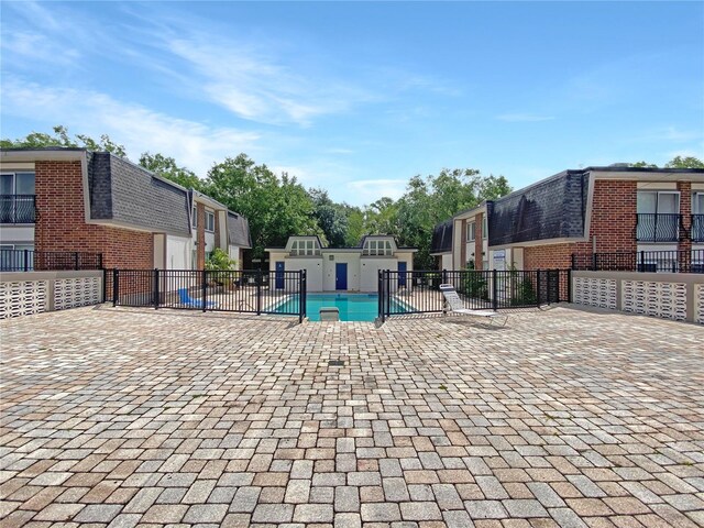 pool with fence and a patio area