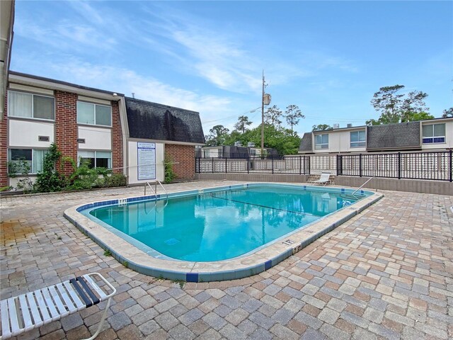 community pool with fence and a patio