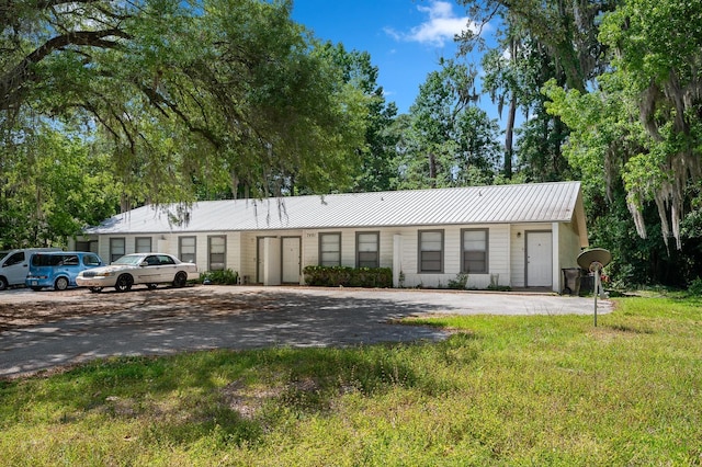 ranch-style home with metal roof and a front yard