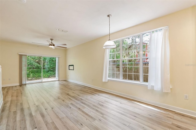 empty room with a ceiling fan, baseboards, visible vents, and light wood-type flooring
