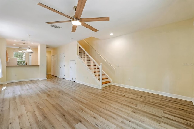 unfurnished living room featuring recessed lighting, light wood finished floors, ceiling fan, and stairway