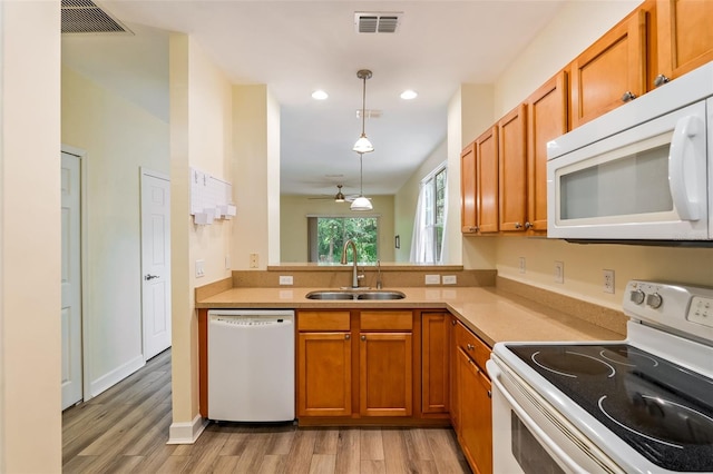 kitchen with a sink, brown cabinets, and white appliances